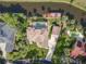 Bird's eye view of a luxury estate with a pool, private dock, expansive driveway, and meticulously landscaped grounds at 448 Warrior Trl, Deltona, FL 32725