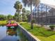 Expansive backyard with a screened-in pool area, lush landscaping, and private dock, perfect for outdoor living at 448 Warrior Trl, Deltona, FL 32725