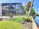 Serene backyard featuring a swimming pool, lush lawn, mature trees, and waterfront access with a private dock at 448 Warrior Trl, Deltona, FL 32725