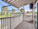 Scenic balcony with white railings, screened enclosure and beautiful view of tropical trees and a nearby pond at 448 Warrior Trl, Deltona, FL 32725