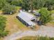 Aerial view of a barn with metal roof, surrounded by grassy areas and trees at 448 Warrior Trl, Deltona, FL 32725