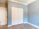 Bedroom with blue walls, closet with bi-fold doors, and wood-look flooring at 448 Warrior Trl, Deltona, FL 32725