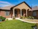 Welcoming front entrance with arched columns, brick facade, landscaped garden, and a well-manicured lawn at 448 Warrior Trl, Deltona, FL 32725