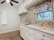 Bright laundry room featuring white cabinets, granite counters, a decorative backsplash, and modern appliances at 448 Warrior Trl, Deltona, FL 32725