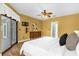 Bright main bedroom boasts wood floors, ceiling fan, and sliding glass doors to the lanai at 448 Warrior Trl, Deltona, FL 32725