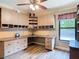 Well-lit home office with built-in desk, storage cabinets, and modern ceiling fan with laminate wood flooring at 448 Warrior Trl, Deltona, FL 32725