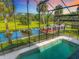 Sparkling pool overlooking the canal and private dock through a screened-in enclosure at 448 Warrior Trl, Deltona, FL 32725
