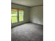 Well-lit bedroom with neutral walls, a large window overlooking green landscape, and plush carpeting at 45814 Lake St, Paisley, FL 32767