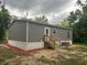 Exterior image of a gray home featuring a front entrance, wooden stairs, and easy access at 45814 Lake St, Paisley, FL 32767
