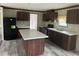 Spacious kitchen features dark cabinetry, a central island, and modern black appliances at 45814 Lake St, Paisley, FL 32767