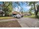 View of the house exterior showing the driveway and front yard with mature trees at 4799 Lighthouse Rd, Orlando, FL 32808