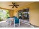 Covered patio with tile flooring, comfortable seating, and view of lush greenery at 4799 Lighthouse Rd, Orlando, FL 32808