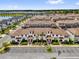 Community aerial view showcasing townhomes, landscaping, parking, and lakeside scenery at 4802 Lullaby Ln, Kissimmee, FL 34746