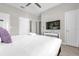 Bright bedroom with modern decor features a ceiling fan, TV, and plush purple pillow at 4802 Lullaby Ln, Kissimmee, FL 34746