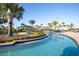 A curved lazy river featuring palm trees, a golf course, and lush landscaping that provides a relaxing waterway experience at 4802 Lullaby Ln, Kissimmee, FL 34746