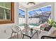 Relaxing screened-in patio with comfortable seating around a glass table and poolside view at 4802 Lullaby Ln, Kissimmee, FL 34746