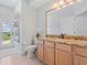 Bathroom featuring wood vanity, granite countertop, walk-in shower, and scenic outdoor view at 4951 Parkview Dr, St Cloud, FL 34771