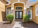 Elegant front entryway with stone accents, double doors, and mature landscaping at 4951 Parkview Dr, St Cloud, FL 34771