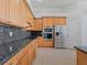 Kitchen featuring stainless steel appliances, granite countertops, and wooden cabinetry at 4951 Parkview Dr, St Cloud, FL 34771