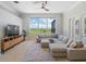 Spacious living room featuring tile flooring, sectional sofa and view to screened pool area at 4951 Parkview Dr, St Cloud, FL 34771