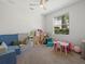 Playroom featuring carpet, overhead fan and a large window with outdoor view at 4951 Parkview Dr, St Cloud, FL 34771