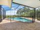 Screened in pool with a black safety fence and a view of trees and a lake at 4951 Parkview Dr, St Cloud, FL 34771