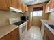 Bright kitchen with white appliances, a window, and a combination of light and dark cabinetry at 5564 Slash Pine Ct # 4, Orlando, FL 32811