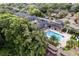 Aerial view of a community pool, clubhouse, and apartments surrounded by trees and parking at 6029 Westgate Dr # 726, Orlando, FL 32835