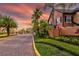 A beautifully landscaped entrance to a gated community with palm trees and a colorful sunset at 6029 Westgate Dr # 726, Orlando, FL 32835