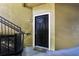 Apartment front door with black trim and a 'Welcome' mat near stairs with black metal handrails at 6029 Westgate Dr # 726, Orlando, FL 32835