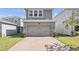 Two-car garage exterior with brick paver driveway and well-maintained landscaping at 640 Bayern Ln, Debary, FL 32713