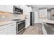 Modern kitchen featuring stainless steel appliances, white cabinets and gray backsplash at 640 Bayern Ln, Debary, FL 32713