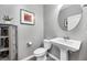 Tastefully decorated powder room featuring pedestal sink, round mirror, and elegant decor at 640 Bayern Ln, Debary, FL 32713