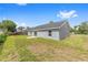 Exterior view of home with slider to small concrete patio in backyard at 654 Ne 130Th Ct, Silver Springs, FL 34488