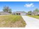 A single-story home with a bright red front door, freshly painted exterior, and a concrete driveway at 654 Ne 130Th Ct, Silver Springs, FL 34488