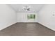 Bright living room features wood-look floors, a ceiling fan, and a large window for natural light at 654 Ne 130Th Ct, Silver Springs, FL 34488