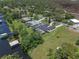 Aerial view of a home featuring a private dock, lake access, pool, and sprawling green lawn at 6790 Bay Shore Dr, St Cloud, FL 34771