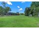 Expansive backyard featuring a manicured lawn, mature trees, screened-in porch, and storage shed at 6790 Bay Shore Dr, St Cloud, FL 34771
