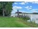 Scenic view of a private dock with a boat lift on a serene lake with a lush green shoreline at 6790 Bay Shore Dr, St Cloud, FL 34771