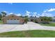 Spacious single-story home with a large driveway, a two-car garage, and lush landscaping at 6790 Bay Shore Dr, St Cloud, FL 34771