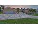 Spacious home featuring a long driveway, attached garage, and well-maintained lawn at 6790 Bay Shore Dr, St Cloud, FL 34771