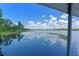 Breathtaking view of the lake from under the dock, showing lily pads and trees along the shoreline at 6790 Bay Shore Dr, St Cloud, FL 34771