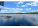 Tranquil view of the lake with a clear blue sky and fluffy white clouds above calm, reflective water at 6790 Bay Shore Dr, St Cloud, FL 34771