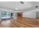 Open-concept living room featuring a stone fireplace, wood floors, and sliding glass doors to pool at 6790 Bay Shore Dr, St Cloud, FL 34771