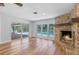 Living room with stone fireplace, wood mantle, hardwood floors and sliding doors to the lanai at 6790 Bay Shore Dr, St Cloud, FL 34771