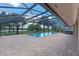 Screened pool features brick pavers, a spa, and a beautiful lake view at 6790 Bay Shore Dr, St Cloud, FL 34771