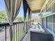 Cozy balcony featuring comfortable outdoor seating with decorative pillows and neutral shade curtains for privacy and shade at 725 Ashworth Overlook Dr # C, Apopka, FL 32712