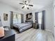 Cozy bedroom featuring a comfortable bed, a ceiling fan, and large windows providing ample natural light at 725 Ashworth Overlook Dr # C, Apopka, FL 32712