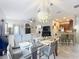 Bright dining area featuring a glass table, modern chandelier, and an open view to the kitchen and living room at 725 Ashworth Overlook Dr # C, Apopka, FL 32712