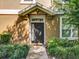 Close-up of the front door and entrance of the home featuring decorative shrubbery at 725 Ashworth Overlook Dr # C, Apopka, FL 32712